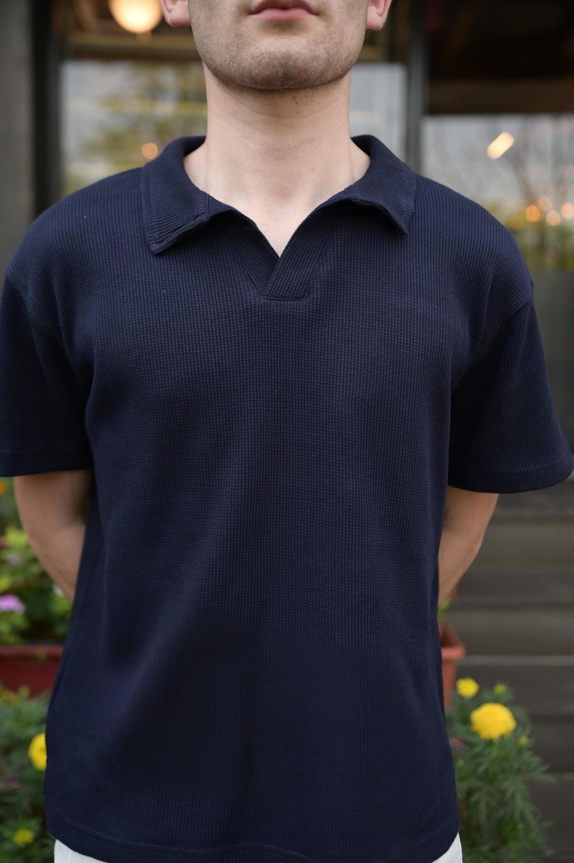 RADIUS midnight navy waffle-knit polo shirt with a modern placket-less V-neck and integrated collar on a man