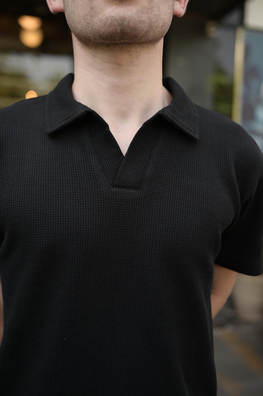 RADIUS jet black waffle-knit polo shirt with a minimalist placket-less V-neck and integrated collar on a man.